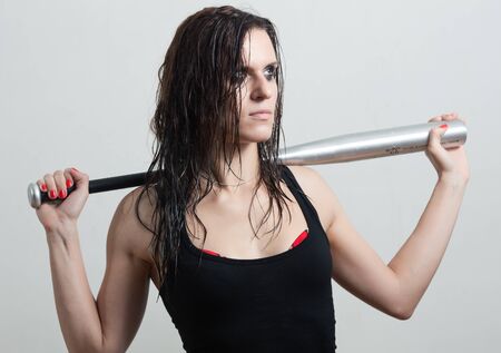 The woman the hooligan holds baseball batの写真素材