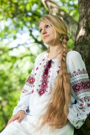 beautiful young girl in peasant dress stands near の写真素材
