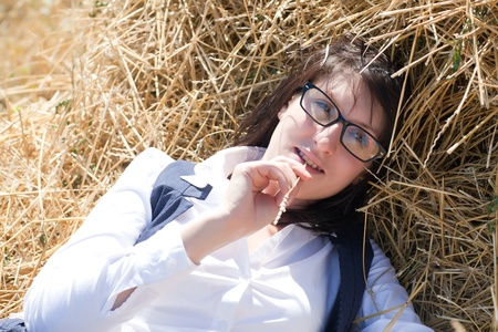 young girl in office clothes resting in the hay