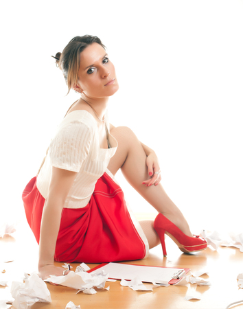 attractive young woman editor making notes in her binder on a white backgroundの写真素材