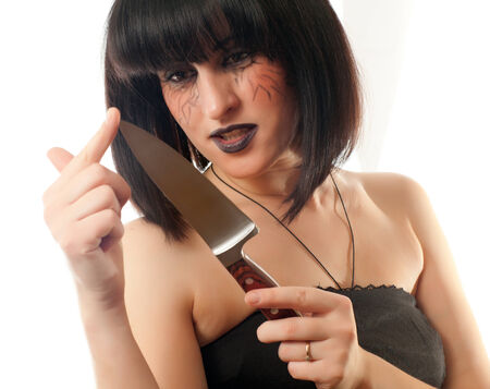 dark gothic woman holding a big knife on a white backgroundの写真素材