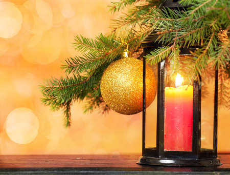 candle lantern, toys and Christmas tree on a yellow background with beautiful bokehの写真素材