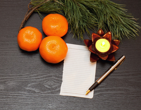 List on a wooden table candle and Christmas decorationsの写真素材