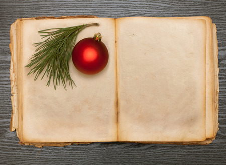 open old book and christmas ball on a wooden tableの写真素材