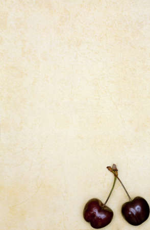Cherry on the old yellow piece of paperの写真素材