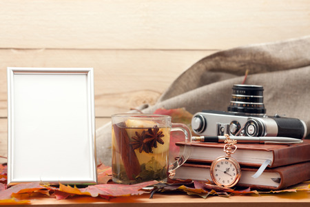 Photo frame, tea, and vintage camera on the table