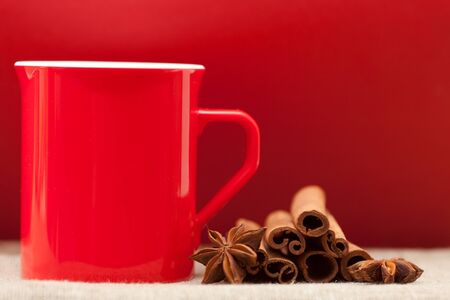 Beautiful red cup on a red background and spicesの写真素材