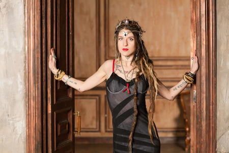 Beautiful young woman in a dress at the doorの写真素材