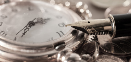 Gold fountain pen and pocket watch close-upの写真素材