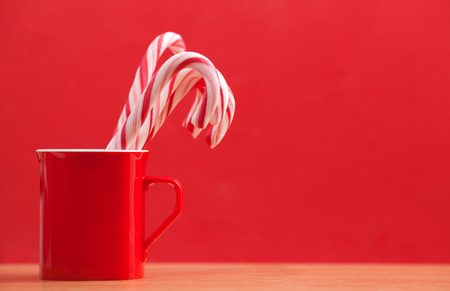 Christmas candies in a mug on a red backgroundの写真素材