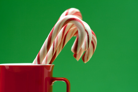 Christmas candies in a mug on a green backgroundの写真素材