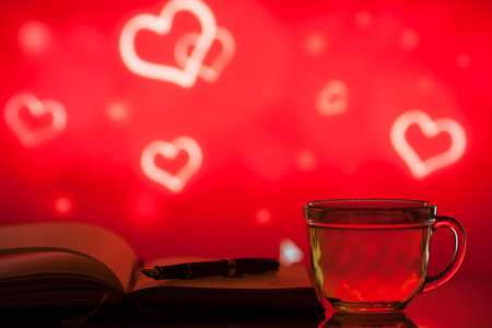 Cup of tea from a glass and  notebook on a bright backgroundの写真素材