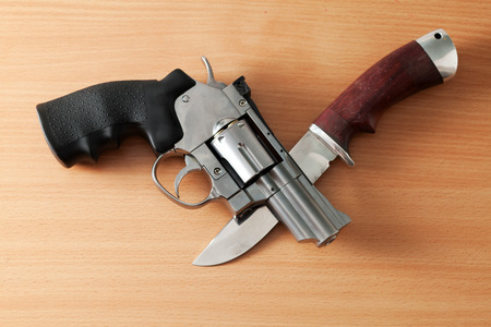 Chromed revolver and a hunting knife on the table