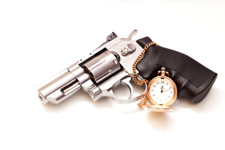 Beautiful revolver and a pocket watch lies on a white backgroundの写真素材