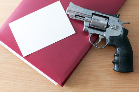 Revolver, folder and photo on the tableの写真素材