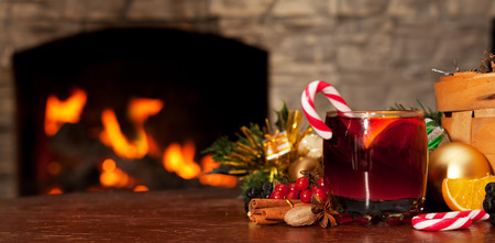Mulled wine and candy on the table near the fireplaceの写真素材