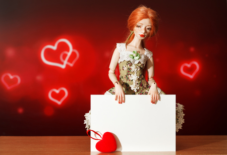 Red-haired doll and note on a beautiful backgroundの写真素材