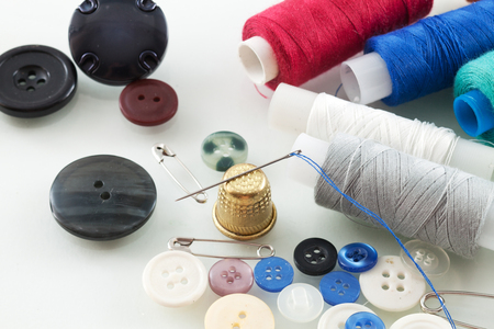 Photo of needle with thread and buttons on a table close-upの写真素材