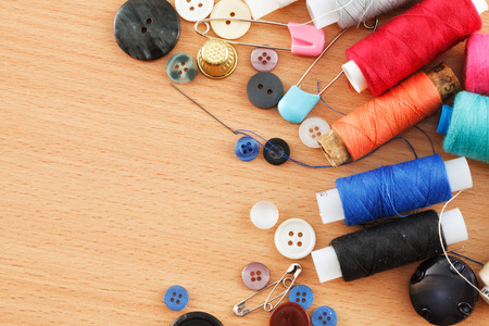 Photo of multi-colored threads and buttons on a table close-upの写真素材
