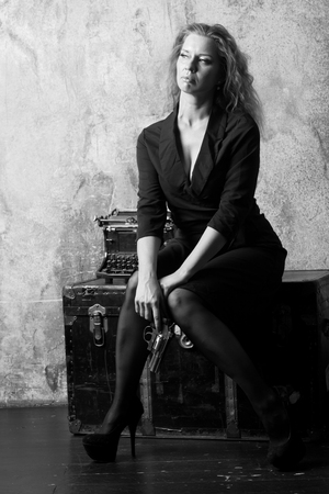 Beautiful woman with a revolver in her handsの写真素材