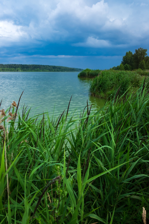 The shore near the lake and storm cloudsの写真素材