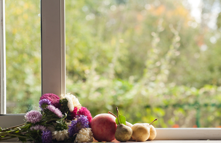 Flowers and fruits on the window with a blurred backgroundの写真素材