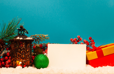 Candle lantern note and gift on snow on blue backgroundの写真素材