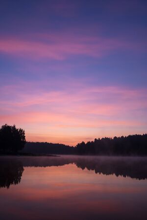 beautiful early morning sunrise over the lake in the forestの写真素材