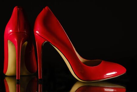 beautiful patent leather shiny female red stilettos on a black background
の写真素材