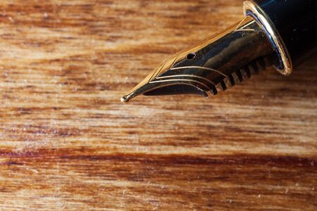 beautiful closeup of a golden fountain pen on a wooden table