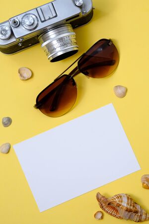 old retro camera, sunglasses and photo card on a yellow background with shells
の写真素材