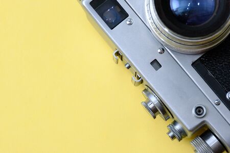 old classic retro camera on yellow background close-up