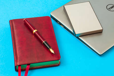 diary with pen and laptop on a blue backgroundのeditorial素材