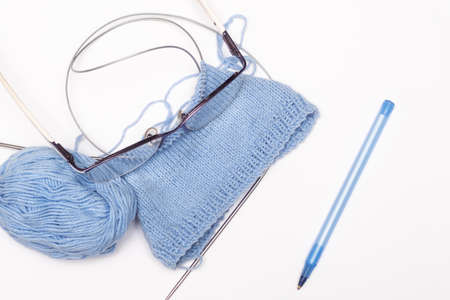 knitting needles and blue ball of thread on white backgroundの写真素材