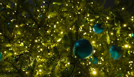 beautiful balls on the Christmas tree with a glowing garland