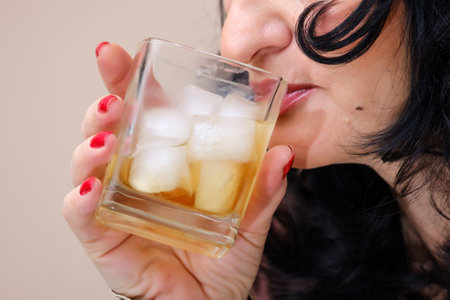 woman drinking from a glass with ice close up