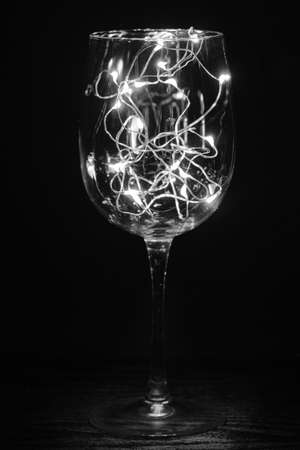 small glowing blue garland in a beautiful glass on a black backgroundの写真素材