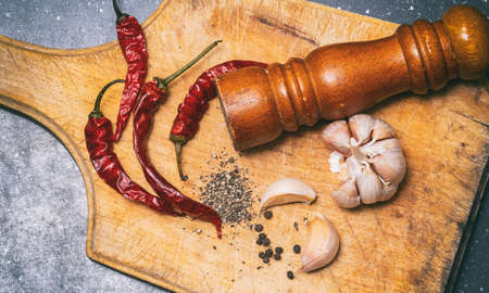 ground black pepper, chili and garlic on a wooden cutting boardの写真素材
