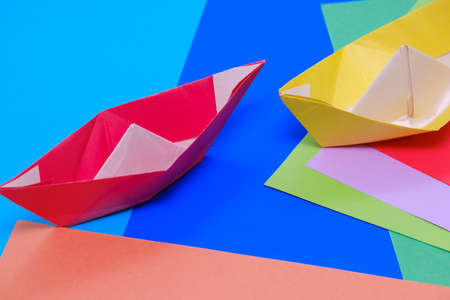 beautiful background of multicolored colored paper and paper boat from top viewの写真素材