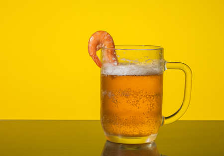 mug with beer and shrimp on yellow backgroundの写真素材