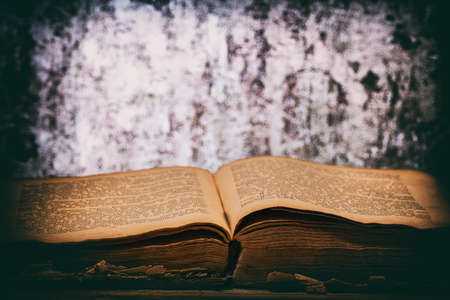 an old open book lies on a wooden table