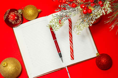 beautiful pen and lollipop cane on notepad on red table and Christmas decorationsの写真素材
