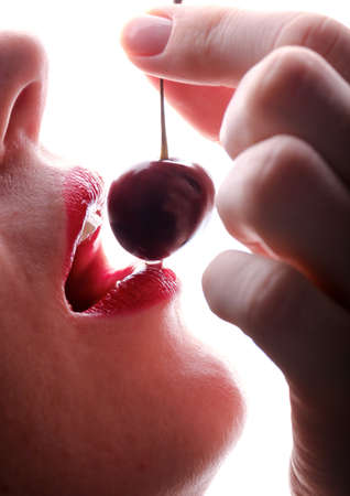 beautiful female lips and cherry berry on a white backgroundの写真素材