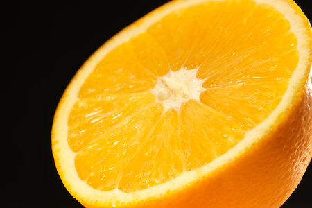 Juicy orange cut in half close-up on a black backgroundの写真素材
