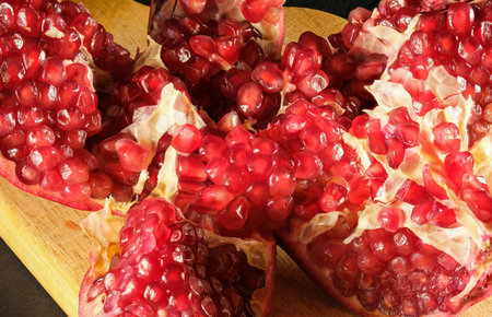 ripe broken pomegranate with red ripe juicy kernels close-upの写真素材