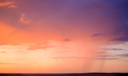 beautiful evening purple-orange sky over fields on the horizonの写真素材