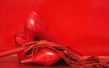 women's red shiny patent leather high heel shoes on red backgroundの写真素材