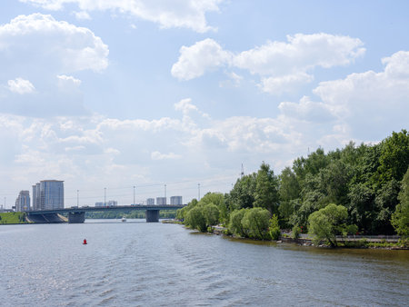 bridge over river and city houses in the distance on a summer dayの写真素材
