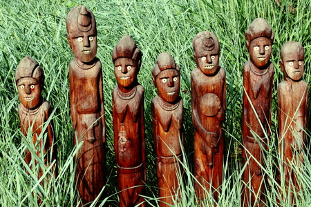 Picture of wooden sculptures with the background of long grass.の写真素材