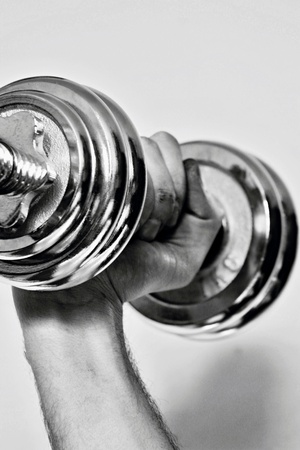 Silver dumbbell for motivation. Hand keep in fist dumbell.の写真素材